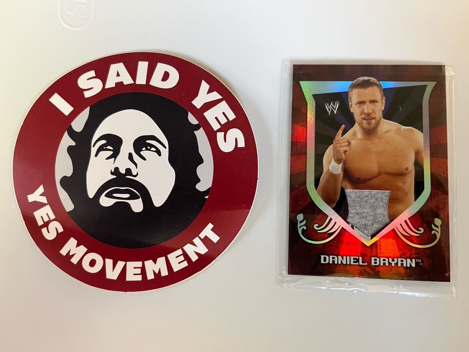 2011 TOPPS WWE CLASSIC DANIEL BRYAN T-SHIRT RELIC CARD & YES MOVEMENT STICKER
